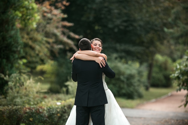 Recién casados sonrientes abrazándose