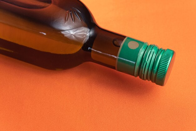 Recipiente de aceite de oliva sobre fondo naranja