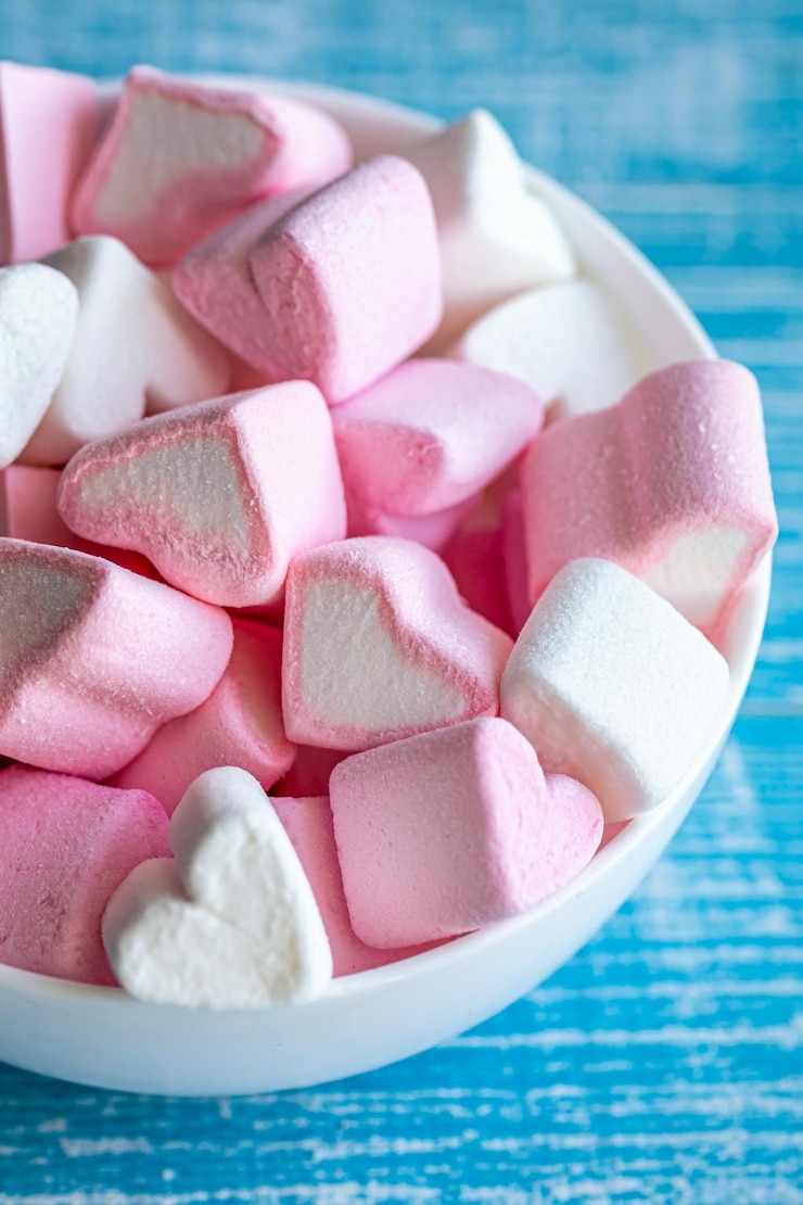 Foto gratuito recipiente con malvaviscos en forma de corazones de cerca