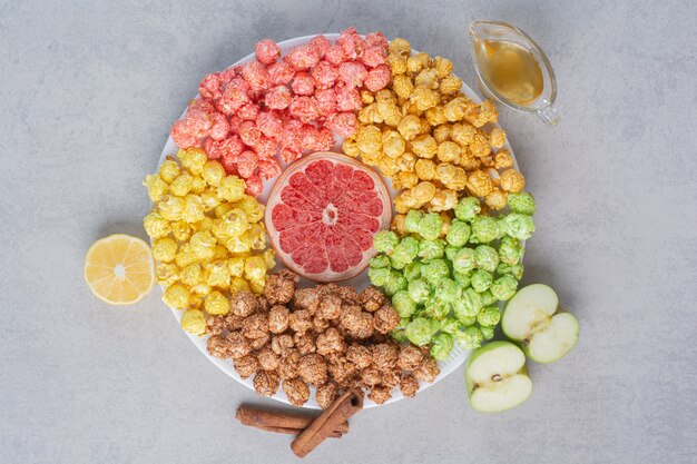 Recipiente pequeño de palomitas de maíz dulces y papas fritas en mármol.