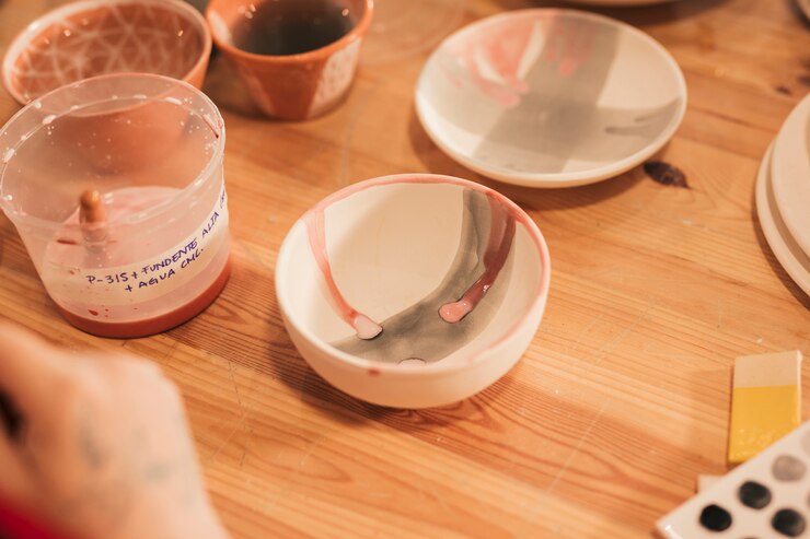 Foto gratuito recipiente y plato de cerámica pintados en mesa de madera