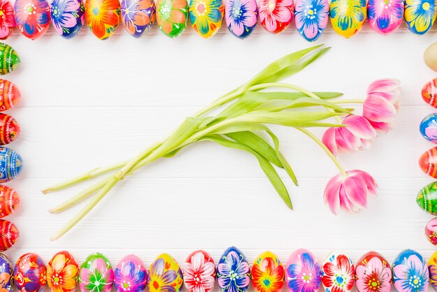 Recolección de huevos de colores en bordes y flores.
