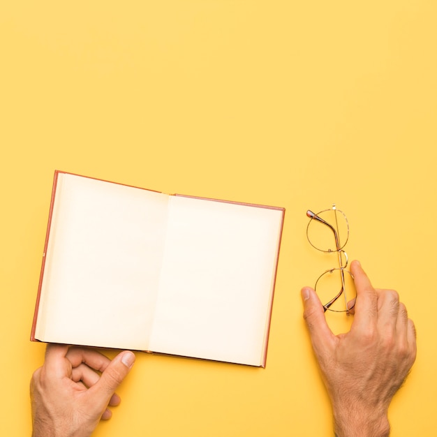 Foto gratuita recortar macho con gafas y cuaderno abierto