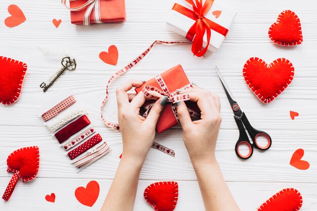 Recortar las manos atando la cinta en la caja de regalo