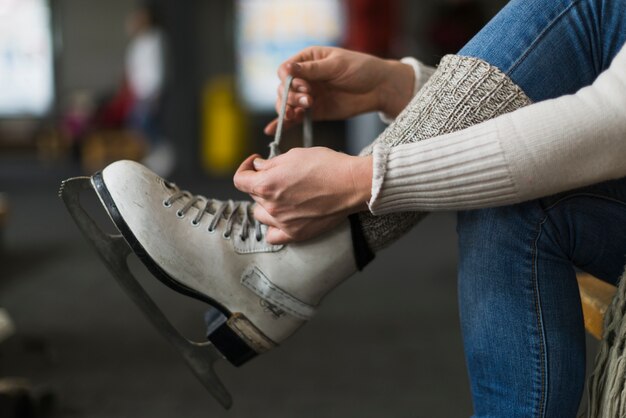 Recortar las manos atando cordones en patines de hielo