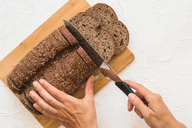 Foto gratuita recortar las manos cortando pan