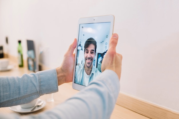 Foto gratuita recortar manos masculinas tomando selfie con tableta