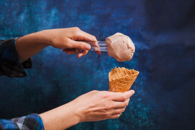 Recortar manos poniendo helado en cono