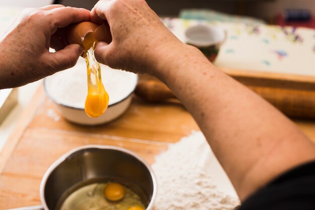 Foto gratuita recortar manos rompiendo huevos para pastelería