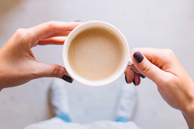 Recortar las manos con una taza de café