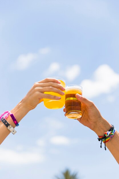 Recortar las manos tintineando vasos con bebidas