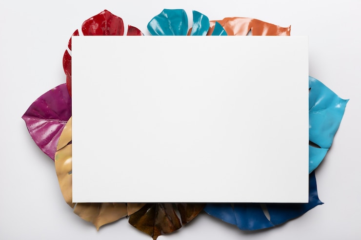 Foto gratuito rectángulo blanco con hojas de colores debajo