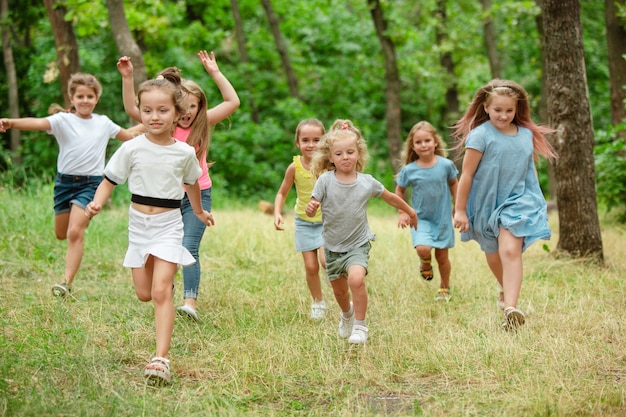 Recuerdos. Niños, niños corriendo en bosque verde.