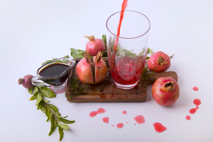 Photo Gratis red pomegranates served with juice and sauce