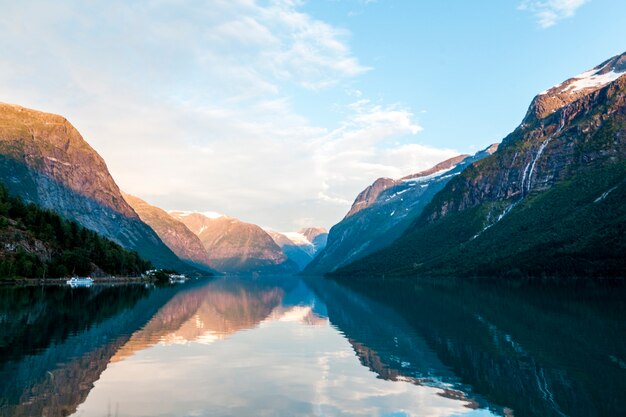 Reflejo de montañas rocosas y cielo en hermoso lago