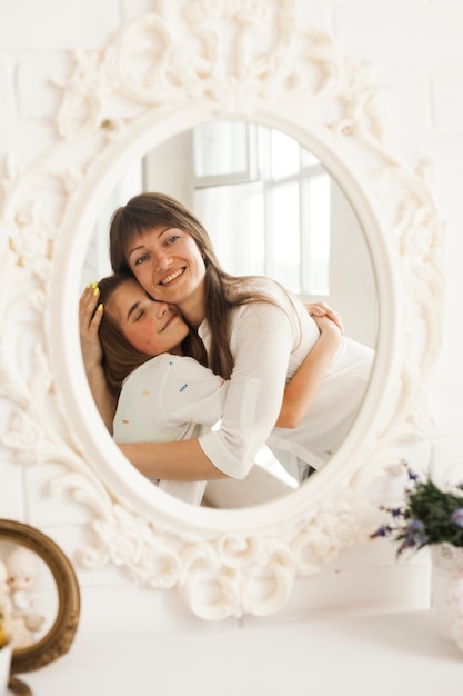 Foto gratuita reflexión de madre sonriente abrazando a su hija