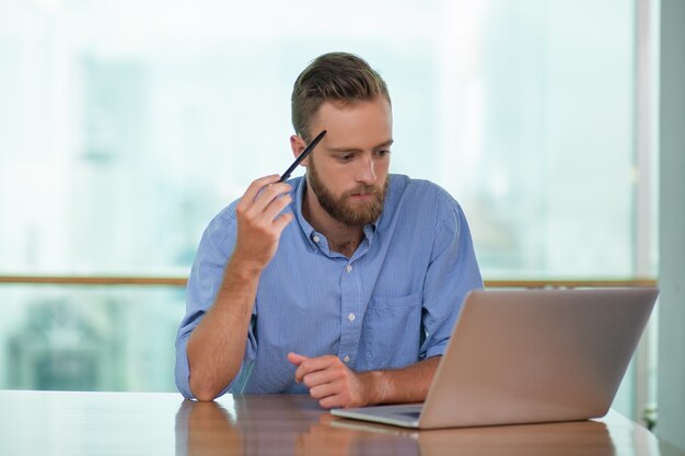 Reflexivo de mediana edad Hombre que trabaja en la computadora portátil