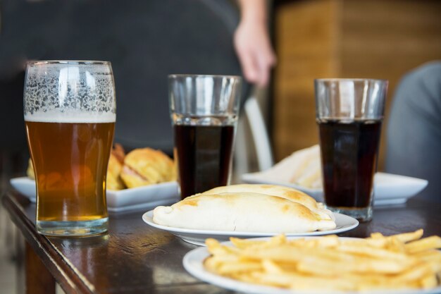 Refrigerio frito con bebidas alcohólicas en la mesa en el bar