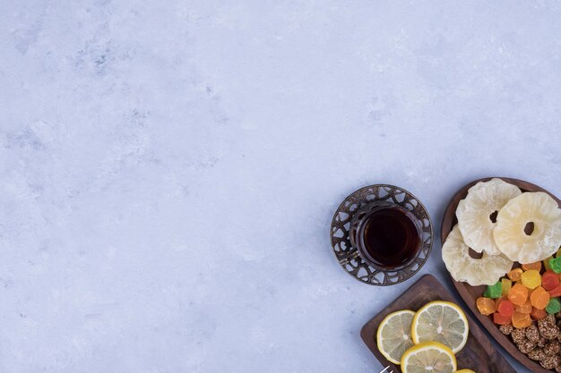 Refrigerio y tabla de dulces servidos con un vaso de té.