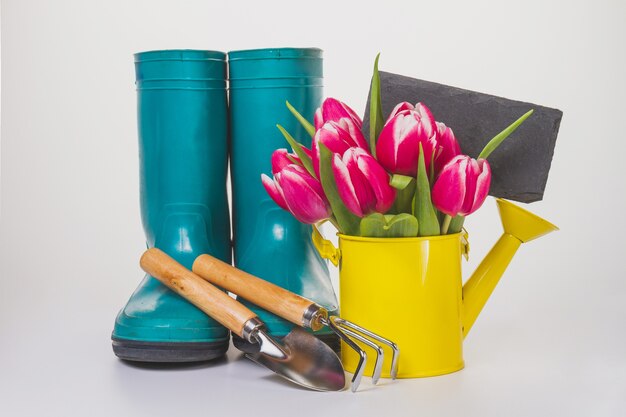 Regadera con flores y artículos de jardinería