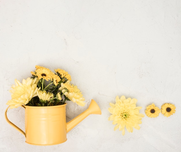 Foto gratuita regadera plana con flores amarillas