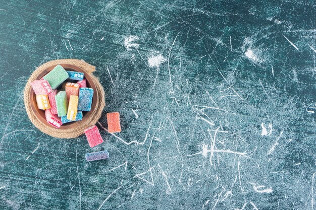 Regaliz de colores en un recipiente hondo colocado sobre la mesa de piedra.