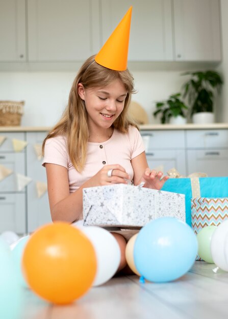 Regalo de apertura de niña sonriente de tiro completo