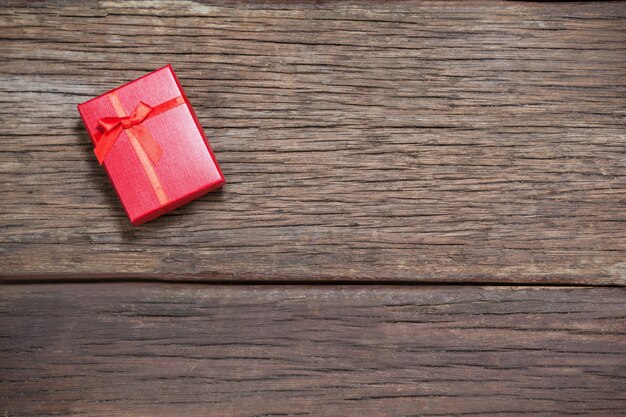 Regalo rojo sobre mesa de madera