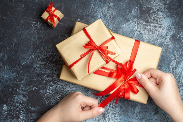 Regalos de Navidad de vista superior atados con lazos rojos sobre el fondo claro-oscuro