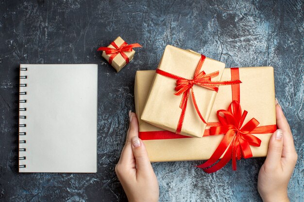 Regalos de Navidad de vista superior atados con lazos rojos sobre el fondo claro-oscuro