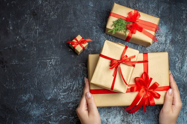 Regalos de Navidad de vista superior atados con lazos rojos sobre el fondo claro-oscuro