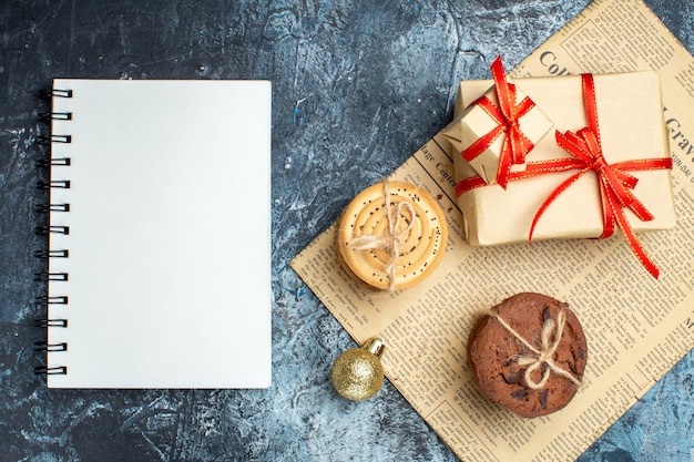 Regalos de Navidad de vista superior con galletas en el fondo claro-oscuro