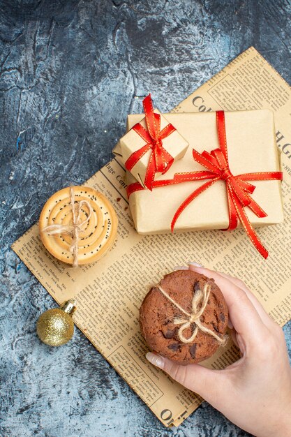 Regalos de Navidad de vista superior con galletas y juguetes sobre fondo claro-oscuro