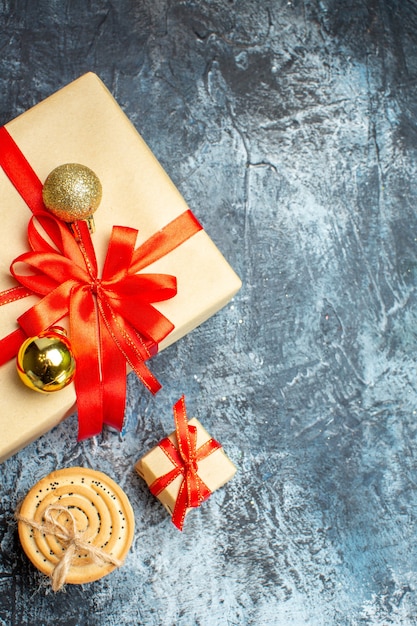 Regalos de Navidad de vista superior con lazo rojo sobre fondo claro-oscuro