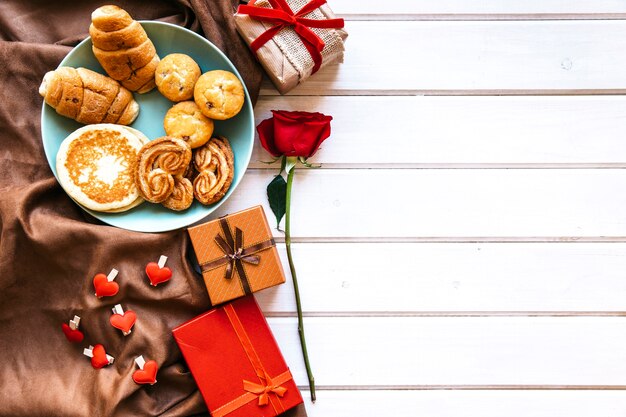 Regalos y rosa cerca de pastelería