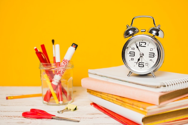 Regreso a la escuela concepto de reloj en una pila de libros