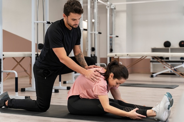 Rehabilitación física de mujer de tiro completo en el gimnasio