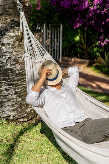 Relajación masculina en una hamaca en el jardín.