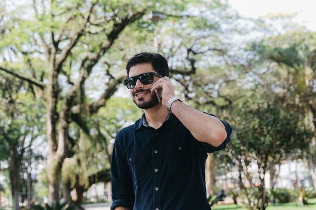 Relajante hombre con llamada telefónica en el parque