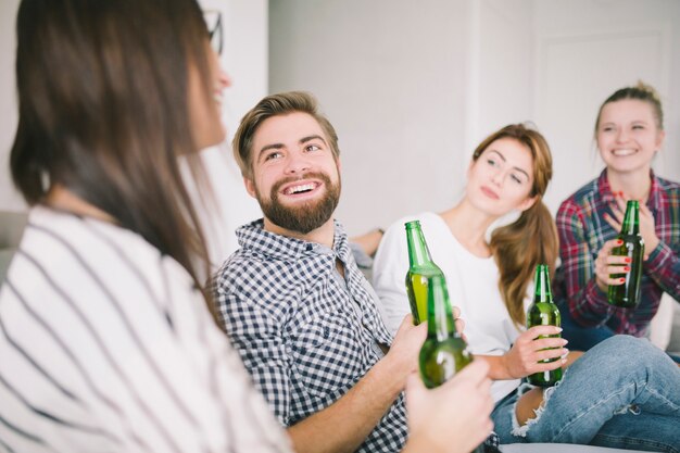 Relajantes jóvenes amigos con cerveza