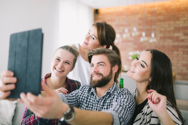 Relajantes jóvenes amigos tomando selfie en casa