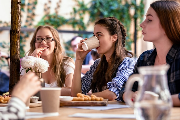 Relajarse con los mejores amigos en la terraza de un café local en los días calurosos y soleados