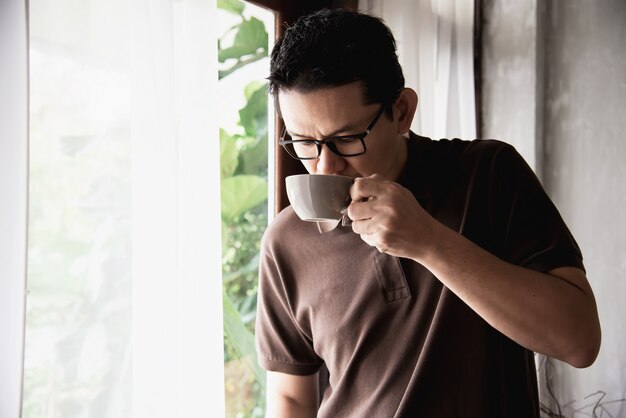 Relaje al hombre asiático que bebe un café