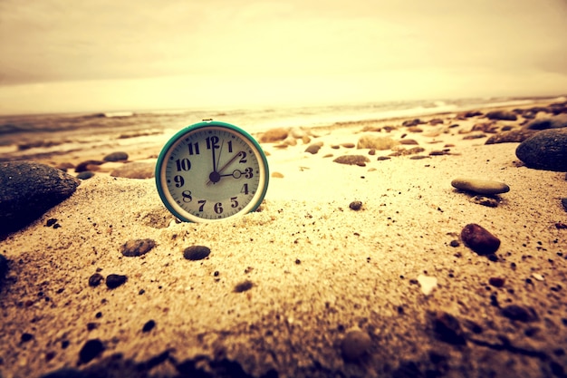 Reloj en la playa. Tiempo y concepto de negocio.