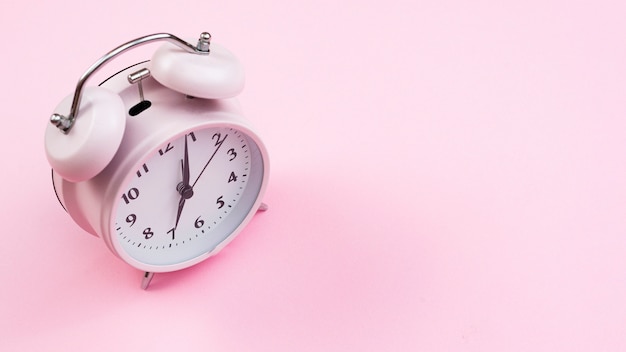Reloj de primer plano con fondo rosa