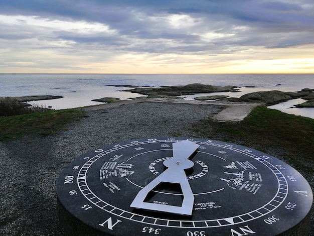 Foto gratuita reloj de sol rodeado por el mar durante la puesta de sol en rakke en noruega