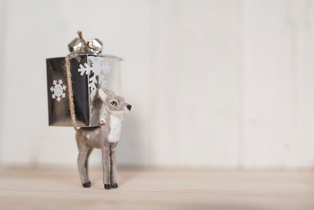 Reno sosteniendo un regalo de Navidad y copie el espacio