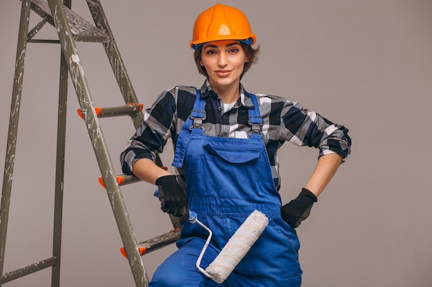 Foto gratuita reparador de mujer con escalera en un uniforme aislado