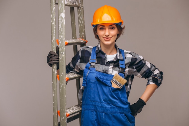 Reparador de mujer con escalera en un uniforme aislado