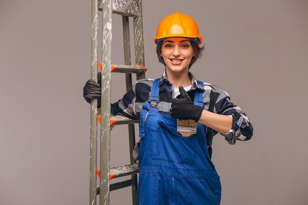 Reparador de mujer con escalera en un uniforme aislado